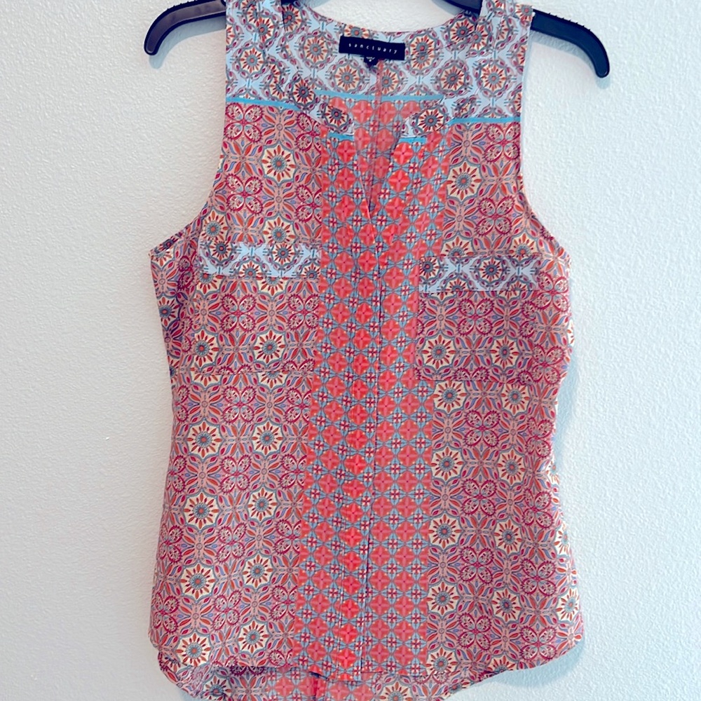 Ladies sleeveless top.
Hidden buttons on front, pockets and a split on back.